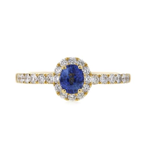 yellow gold ring with oval cut blue sapphire set in halo of white diamond rounds that extend onto band