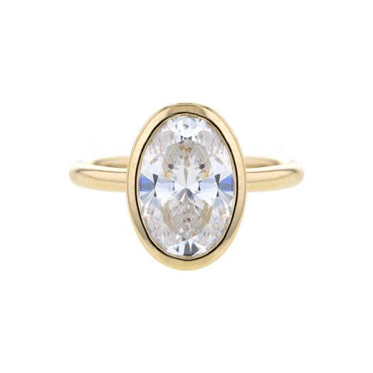yellow gold band with oval bezel setting with cubic zirconia oval stone in center