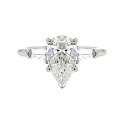 platinum engagement ring with pear-cut center stone, flanked by two tapered baguette side stones on each side