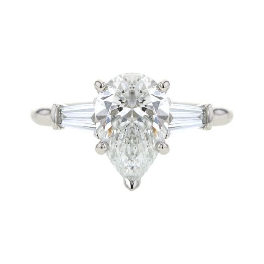 platinum engagement ring with pear-cut center stone and tapered baguette diamonds on each side