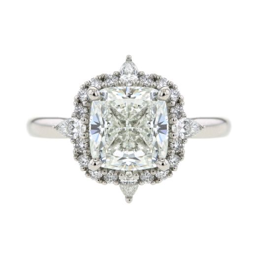 cushion cut center stone set in halo of white diamond rounds and pear-cut diamonds accented each point on platinum band