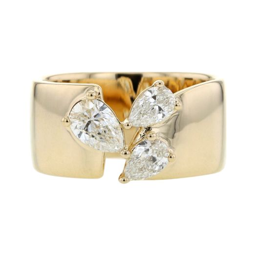 large yellow gold cigar band ring featuring three pear-cut diamonds in different sizes lining unique openwork split design