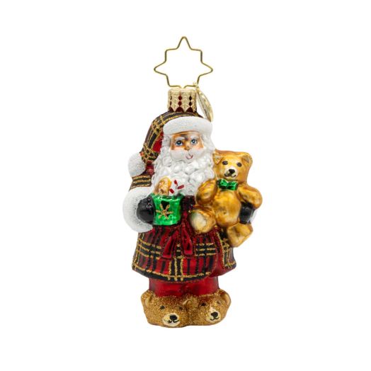Santa in plaid pajamas while holding a teddy bear ornament