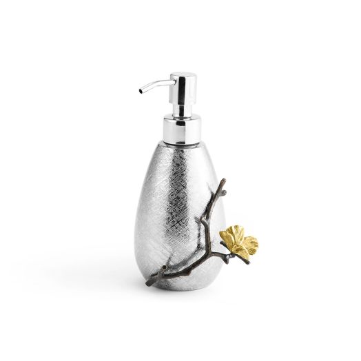 A tall cylindrical stainless steel soap dispenser with a gently curved pump, accented by brass details and etched with a butterfly-inspired ginkgo leaf texture.