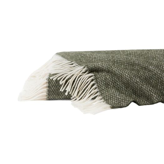 green blanket with white tassle ends